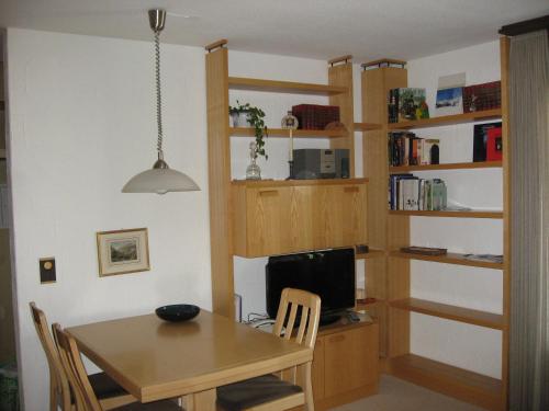 ein Esszimmer mit einem Tisch und einem Schreibtisch mit einem Computer in der Unterkunft Haus Brüggli B24 in Arosa