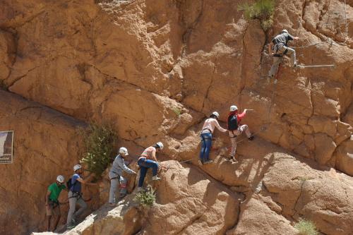 a group of people climbing on a rocky mountain at Les Jardins De Todgha gorges de todra tinghir in Aït Baha