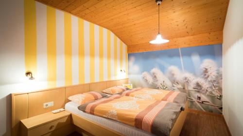 een slaapkamer met een bed met een gestreepte muur bij Apartment Sonnwies in Verano