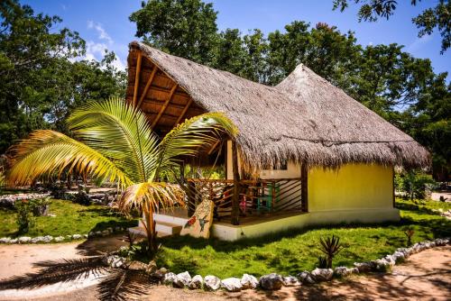 a small house with a thatched roof at Villa Morena Boutique Hotel Ecoliving in Akumal