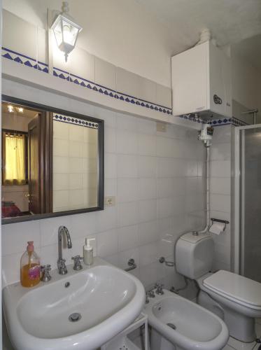 a bathroom with a sink and a toilet and a mirror at Il Cielo di Lucio in Pisa