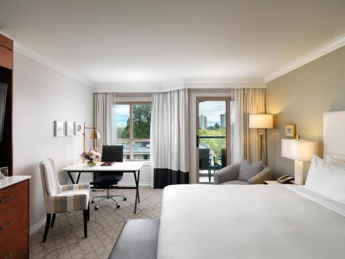 a hotel room with a bed and a desk at Hotel Grand Pacific in Victoria