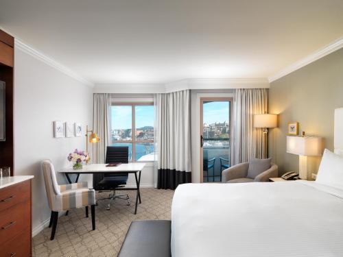 ビクトリアにあるホテル グランド パシフィックのベッドとデスクが備わるホテルルームです。