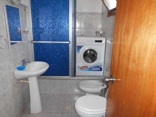 un bagno con un lavandino del water e una lavatrice di Mi Capricho a Barra de Maldonado