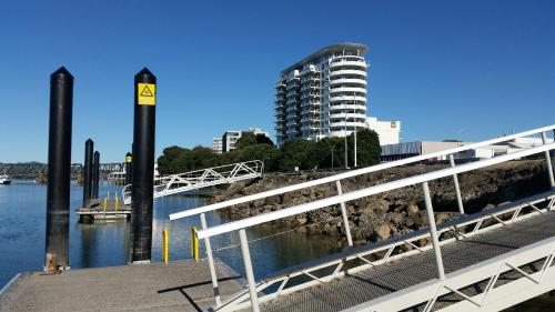 a bridge over a river with a building in the background at Loft 109 Backpackers Hostel in Tauranga