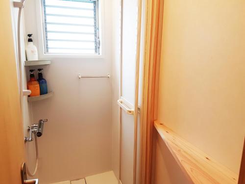 a bathroom with a toilet and a window at Poly Hostel 2 Namba in Osaka