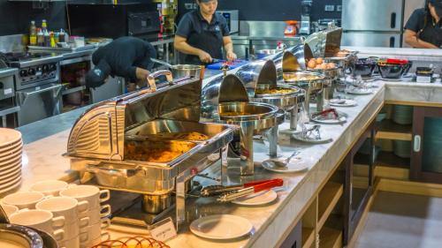 una linea a buffet in un ristorante con persone che preparano il cibo di Unique Regency Pattaya a Pattaya Sud