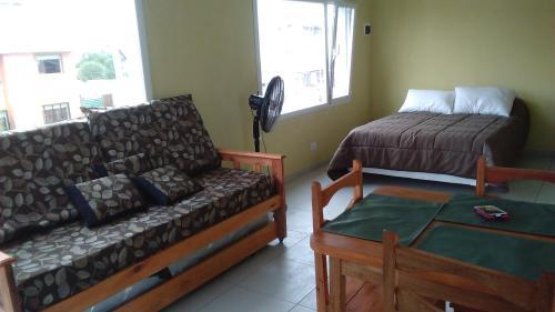 a living room with a couch and a bed at Apartamentos Croacia del Mar in Santa Clara del Mar
