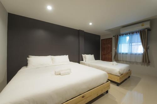 um quarto com 2 camas e lençóis brancos em PUNSUK@PRASING em Chiang Mai