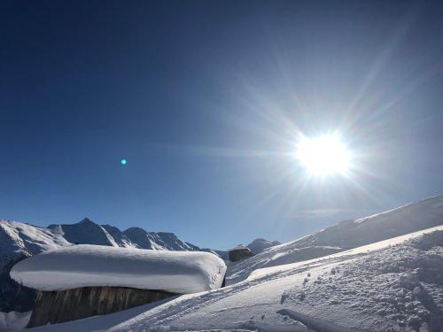 a snow covered mountain with the sun in the sky at Hotel Garni Central - Zimmer - Studios - Apartments in Kappl