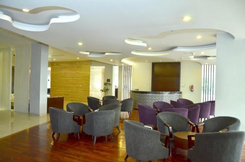 a waiting room with purple chairs and a bar at Grand Cakra Hotel Malang in Malang