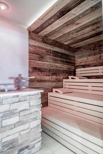 a room with wooden walls and a stone wall at Hotel Weisses Lamm in See