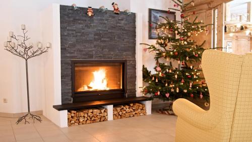 a fireplace in a living room with a christmas tree at Landhaus Lechthaler in Sankt Anton am Arlberg