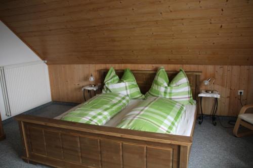 a bed with green and white pillows in a room at Stöffeigut in Mariapfarr