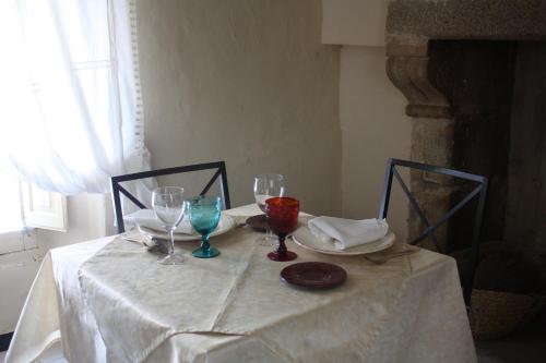 una mesa con mantel blanco y copas de vino en La Cantarera, en Herguijuela