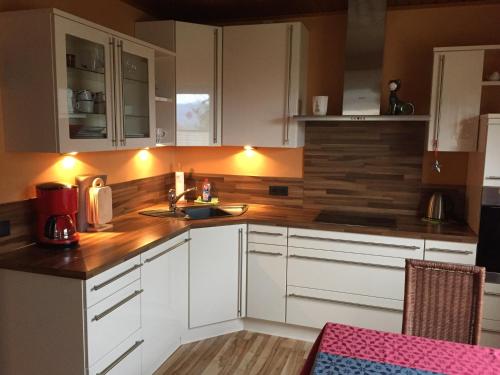 a kitchen with white cabinets and a sink at Ferienwohnung Klaus in Ebermannstadt