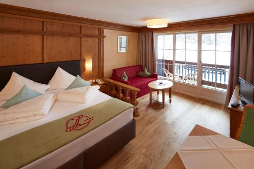 Hotel Lumberger Hof في غران: غرفه فندقيه بسرير وشرفه