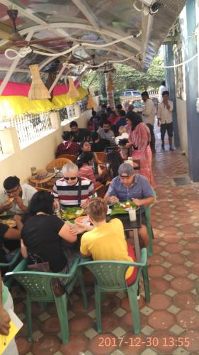 a group of people sitting at tables eating food at Hotel Varsha Hampi in Hampi