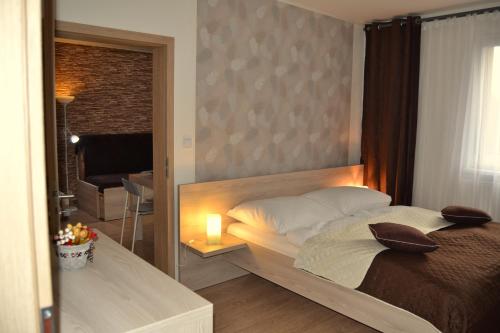 ein Schlafzimmer mit einem Bett mit einer Kerze darauf in der Unterkunft Apartmány Rysí skála in Loučná nad Desnou
