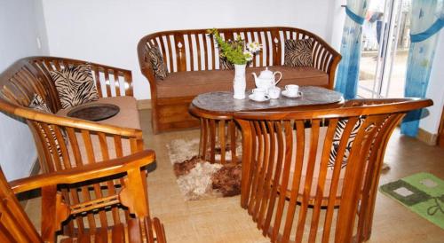 a dining room table with chairs and a table with flowers on it at Winter Dream Holiday Bungalow Nuwara Eliya in Nuwara Eliya