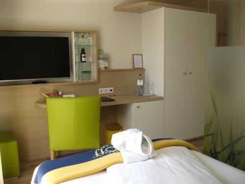 a room with a tv and a bed and a desk at Seehotel OFF in Meersburg