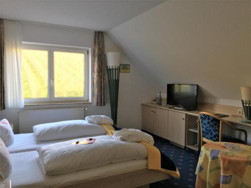 メーアスブルクにあるSeehotel OFFのベッド2台とテレビが備わるホテルルームです。