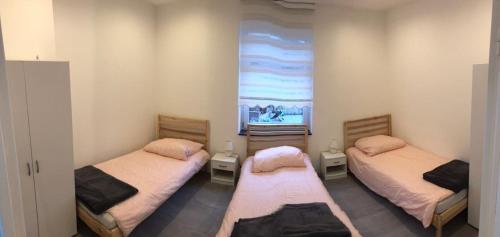 een kamer met 2 aparte bedden en een raam bij Adel in Essen