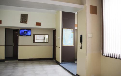 a hallway of a hospital with a door and a television at Hotel City in Trelew