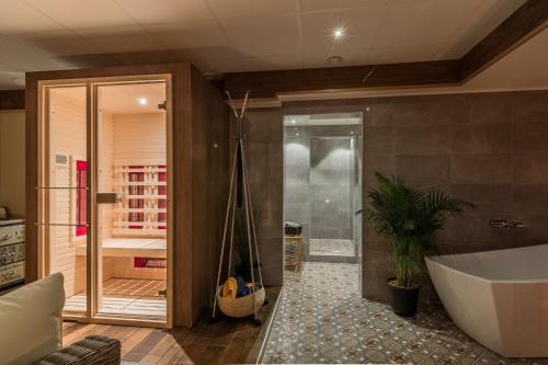uma casa de banho com banheira e uma planta em Skultuna Hotell & Konferens em Skultuna