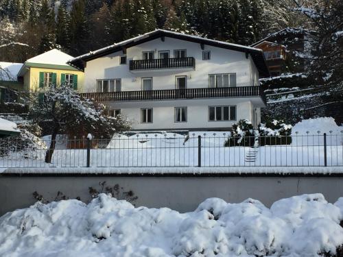 ein weißes Haus mit einem Zaun im Schnee in der Unterkunft Ferienhaus Vera in Obervellach