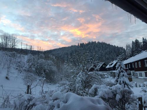 a view of a snow covered yard with a sunset at Ferienwohnung An der Innerste in Wildemann