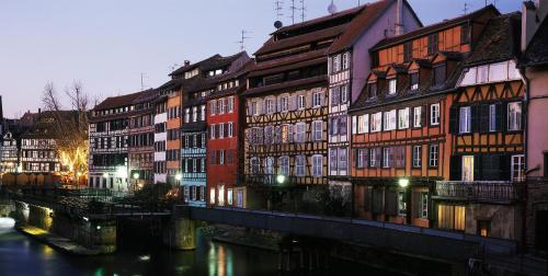a group of buildings next to a river at Studio des Musiciens - quartier Orangerie in Strasbourg