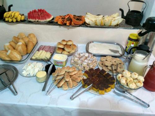 une table recouverte de différents types de nourriture sur les cuillères dans l'établissement Pousada Maciel, à São Thomé das Letras