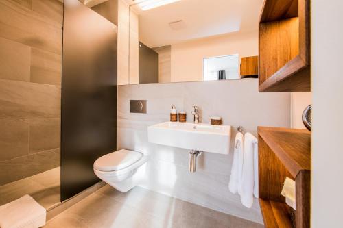 a bathroom with a sink and a toilet at Boutique Hotel NI-MO in Zürich