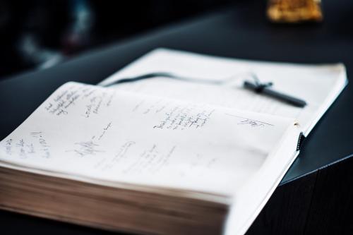 a piece of paper with a pen on top of a book at Boutique Hotel NI-MO in Zürich