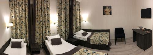 a hotel room with two beds and a desk at Non-stop hotel in Boryspilʼ