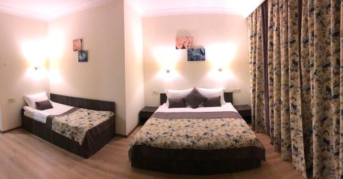 a hotel room with two beds and curtains at Non-stop hotel in Boryspilʼ
