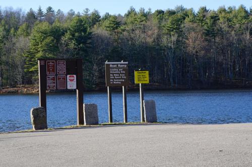 a group of signs in front of a body of water at Economy Lodge 682 Main St Sturbridge in Sturbridge