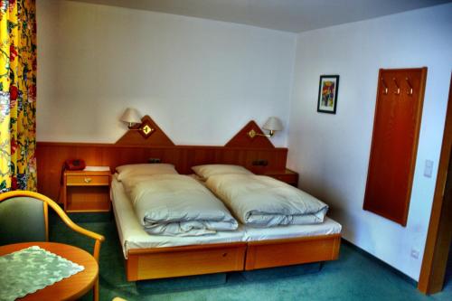 a bedroom with a bed with a wooden head board at Braunschweiger Hof in Münchberg