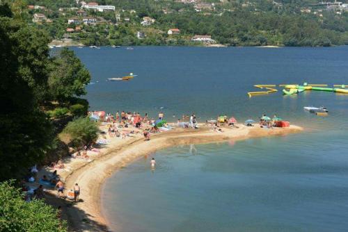 a group of people on a beach in the water at Casa Feijao - Alojamento Local in Geres