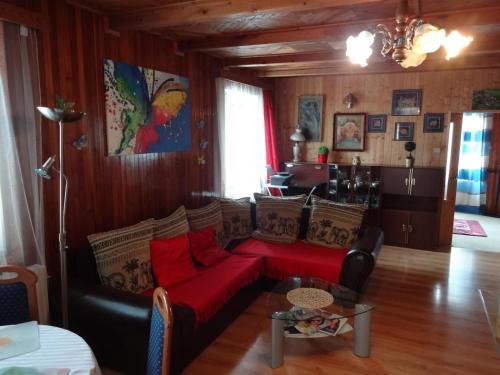 ein Wohnzimmer mit einem roten Sofa und einem Tisch in der Unterkunft Penzion Tony-APP Beroun in Beroun