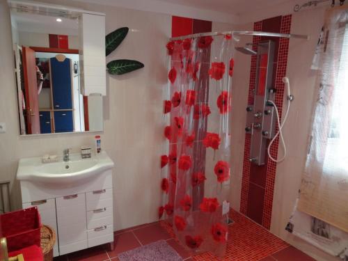 łazienka z prysznicem z czerwonymi kwiatami na zasłonie prysznicową w obiekcie Penzion Tony-APP Beroun w mieście Beroun