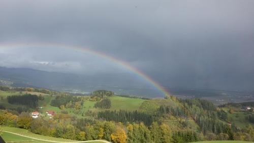 a rainbow in the sky over a green field at Lindlhof Fam. Taferner in Sankt Andrä