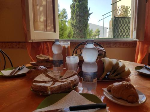 a table with two bottles of water and bread at Il Melangolo in SantʼAntìoco