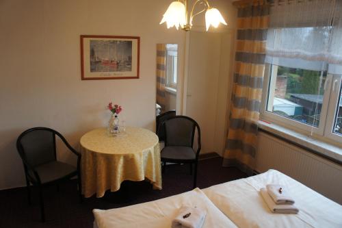 a room with a table and two beds and a window at Corso in Bad Wilsnack