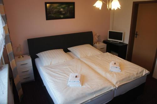 a bedroom with a bed with white towels on it at Corso in Bad Wilsnack