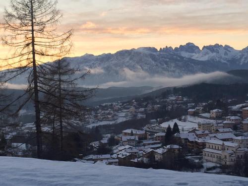 a town in the snow with mountains in the background at CA' del GIACOMINO in Baselga di Pinè