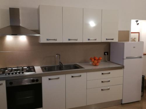 a kitchen with white cabinets and a sink at CasAmato in Benevento
