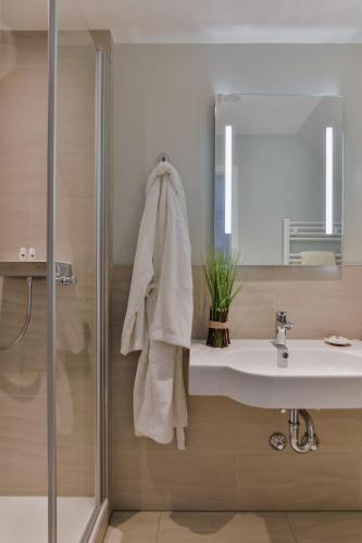 a bathroom with a sink and a shower at Hotel am Südwäldchen in Westerland (Sylt)