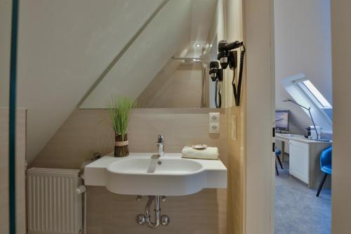 a bathroom with a sink and a staircase at Hotel am Südwäldchen in Westerland (Sylt)